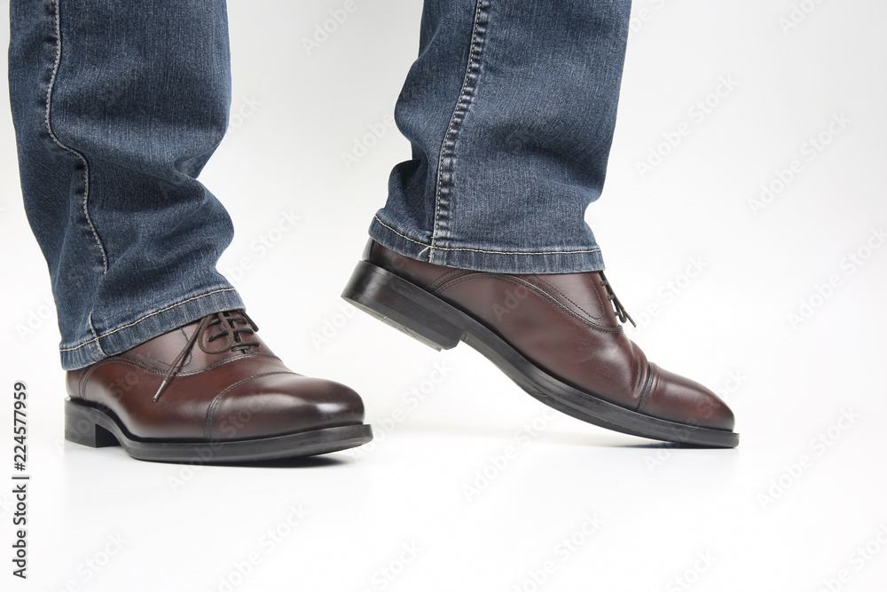 Poster men's legs in jeans shod in classic brown oxford shoes