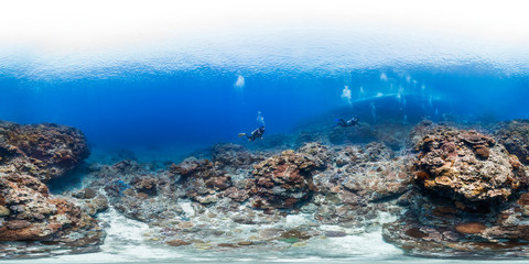 Three divers over healthy coral in taiwan