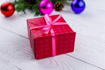 Gift box and Christmas decorations on white wooden table