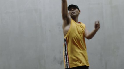 dancing man young happy street dancer performing various freestyle dance moves fit mixed race male practicing in grungy warehouse wearing yellow vest close up