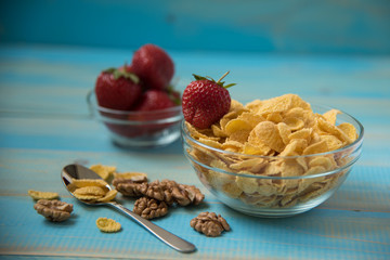 Tasty cornflakes with walnut in glass bowl