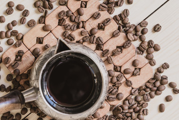 Old copper coffee pot and coffee beans on light rustic background, horizontal