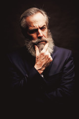 mature male model wearing suit with grey hairstyle and beard