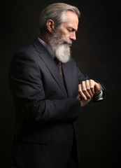 mature male model wearing suit with grey hairstyle and beard