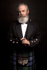 mature male model wearing kilt with grey hairstyle and beard