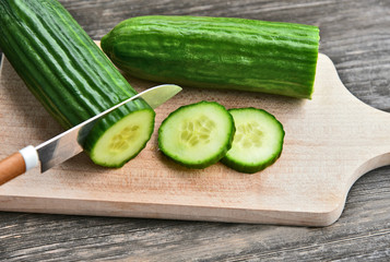 Cucumber seeds are edible and very nutritious..Fresh Cucumber slice on wooden board with wooden background.