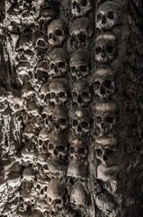 Human skulls and bones at a wall in the bone chapel Evora