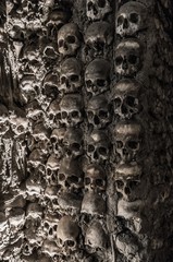 Human skulls and bones at a wall in the bone chapel Evora