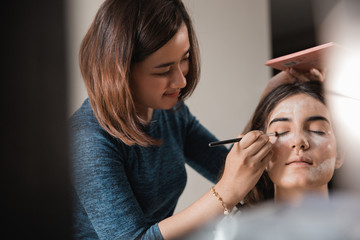 woman having make up applying by artist 