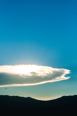 sun behind clouds on sunset