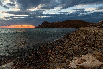 Sunset line on dark sky,sea and beach.