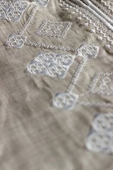 Fototapeta na wymiar Embroidered linen shirt, white ornament, close