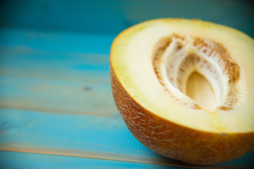 half ripe melon on a rustic, blue wooden background