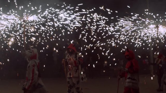 Traditional correfoc performance. In the correfoc, a group of individuals will dress as devils or Diables and light fireworks - fixed on devil's pitchforks or strung above the route