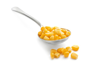 Spoon with corn kernels on white background