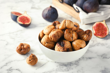 Bowl with delicious dried figs on marble table. Organic snack