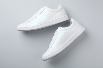 Pair of trendy sneakers on light background, flat lay