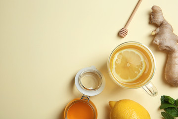 Flat lay composition with cup of lemon tea, ginger and honey on color background. Space for text