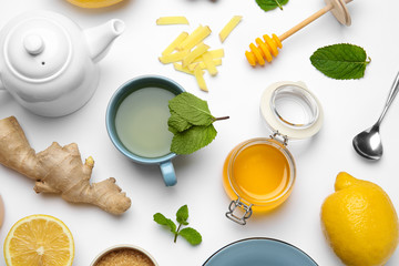 Composition with lemon tea, honey and ginger on white background, top view