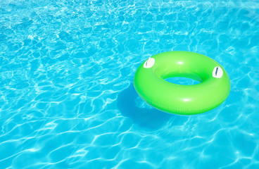 Inflatable ring floating in swimming pool on sunny day. Space for text