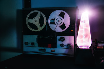 Old reel retro tape recorder and electrostatic plasma Tesla lamp in dark room