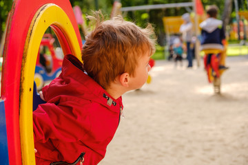 Boy playing on playground carousel in the park