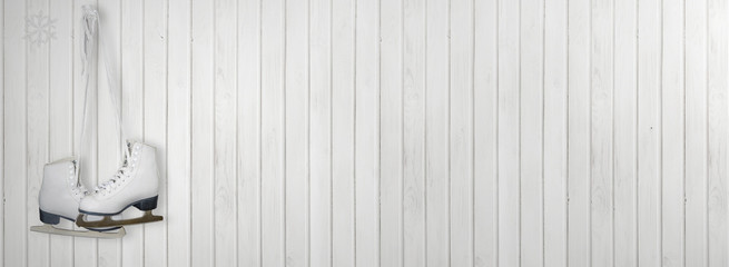 Old white skates for figure skating on a White wood vintage or grungy background.