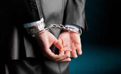 Cropped image of male hands in handcuffs