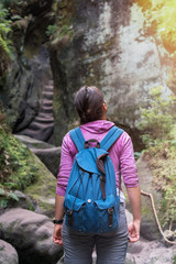 Junge Wanderin blickt hoch zu einem Felsen, Wandern im Gebirge