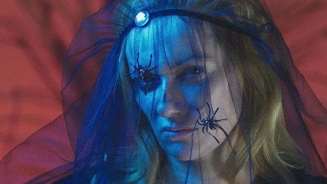 4k, slow motion, Halloween. Woman in costume of a terrible witch, swears looking at the camera, close-up