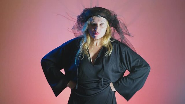 4k, slow motion, Halloween. Woman in costume of a terrible witch, swears looking at the camera
