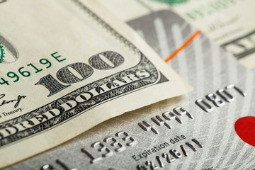 Hundred dollar bill on top of a credit card
