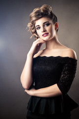 Fototapeta premium portrait charming woman in black dress with retro hairstyle