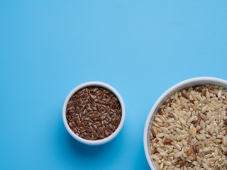 brown rice and flax in white cups on a blue background