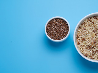brown rice and flax in white cups on a blue background