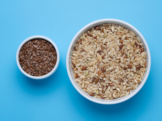 brown rice and flax in white cups on a blue background