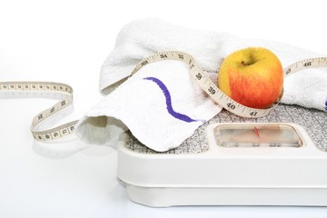 Loosing weight weighing scale and eating healthy in the new year starting with a delicious apple