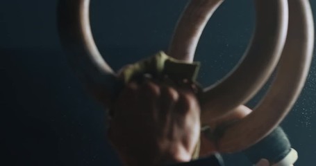 fitness woman training gymnastics exercise using rings enjoying intense muscle workout lifting weight sportswoman bodybuilding olympics practice in gym close up hands slow motion