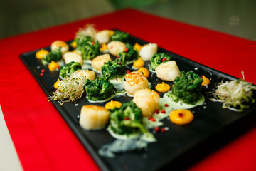 Scallops in pumpkin sauce on a black plate