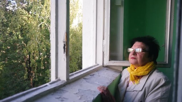 an elderly woman looking out the window. MLS 1