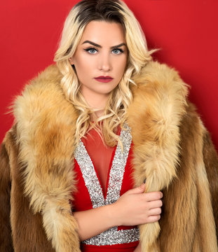 Young Woman In Red Dress And Fur Coat