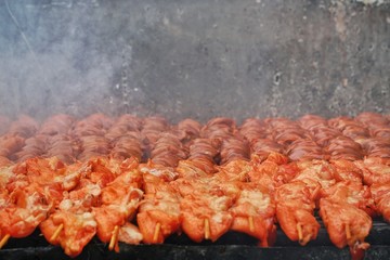Grilled barbecue meat on skewers over fire with smoke cooking on a coal.Preparation of delicious appetizing giblet chickens roasted on hot grill.Food,Healthy,Picnic Concept.