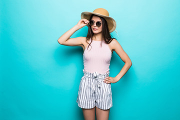Portrait of pretty woman in sunglasses and hat over blue colorful. Summer concept.