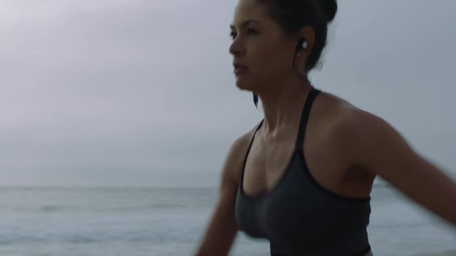 focused young woman runner on beach running exercising endurance workout fit female athlete healthy slim body 