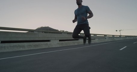 young african american runner man stretching preparing for running workout performing warm up exercise in urban city at sunrise enjoying healthy fitness lifestyle - Powered by Adobe
