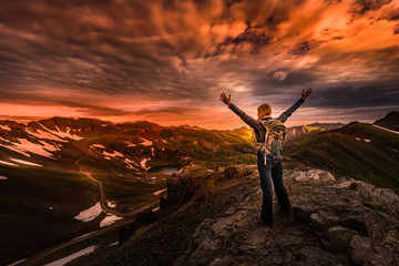 Young Woman Backpacker in Victory Pose with raised up arms on top of the Mountain Colorado USA