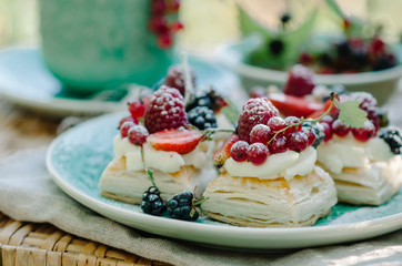 Puff pastry cakes with cream filling and berry topping