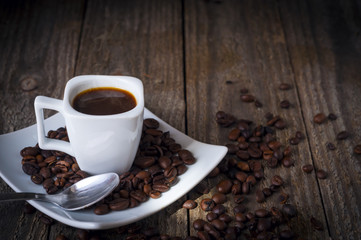 Square coffee cup on wooden table with coffee beans