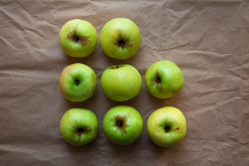Green apples isolated on beige paper background from a high angle view