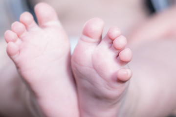 Newborn baby feet. Horizontal. Space for text. Background out of focus.